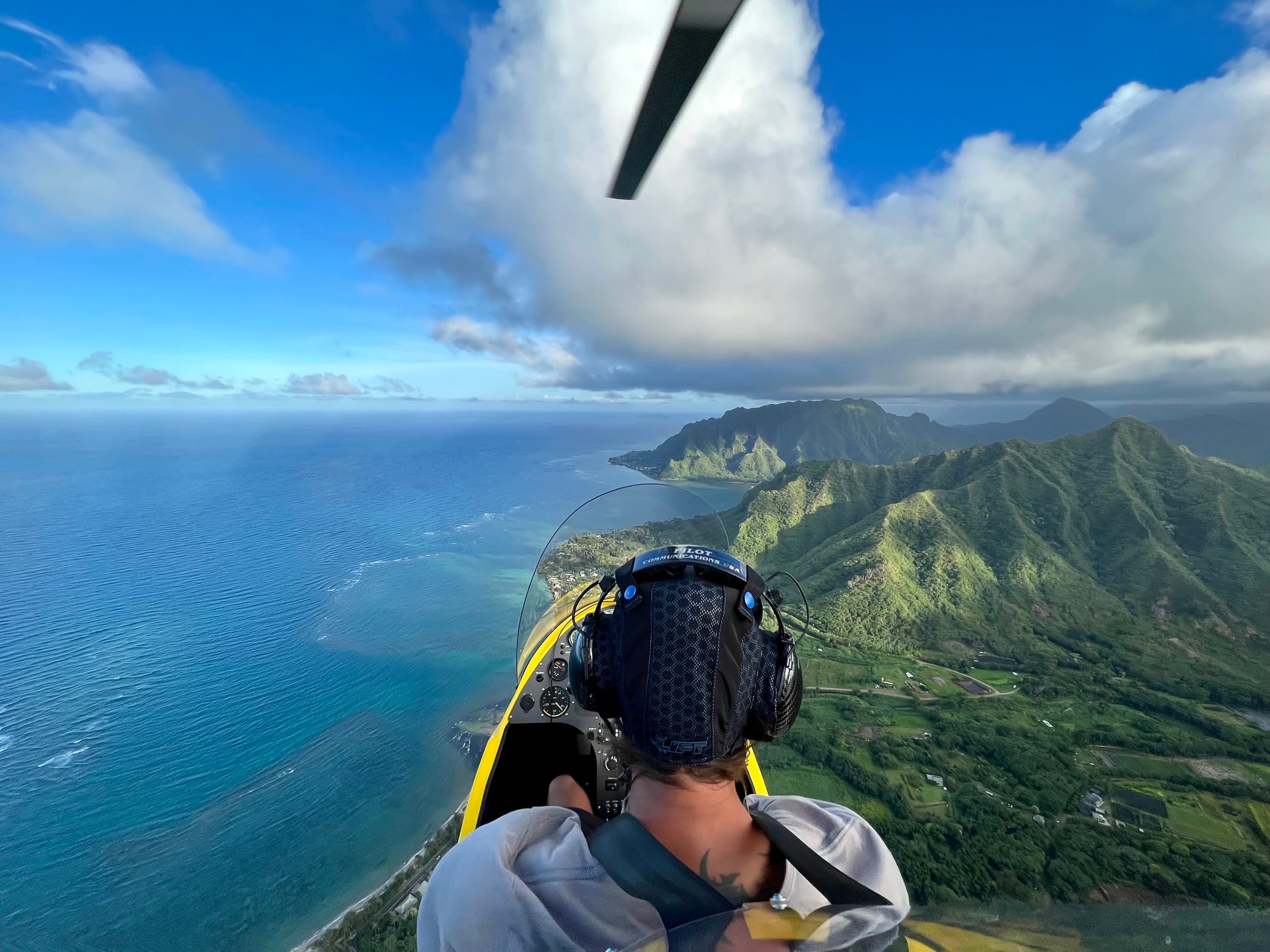 Open-cockpit point of view from the gyroplane over the coastline.